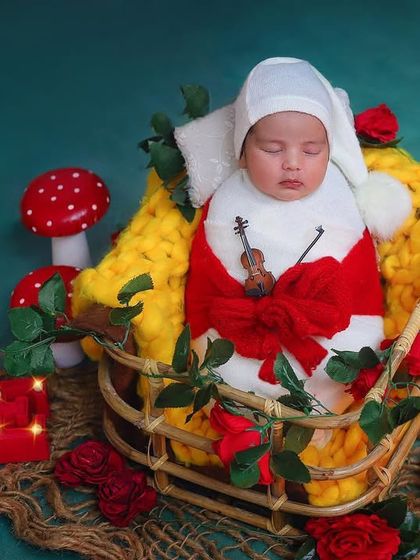 Love is in the air with this adorable Valentine's Day themed setup. The baby is dressed in red and white and surrounded by hearts and roses, making for a super sweet portrait.
