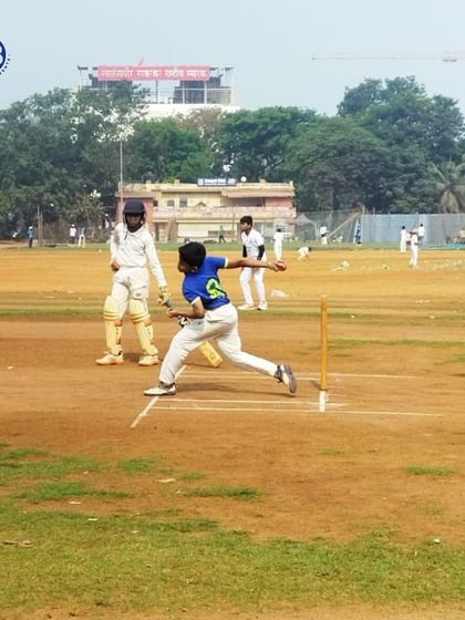 A young bowler in mid-action on a classic dirt pitch, demonstrating the fundamental skills we teach in our cricket programs.