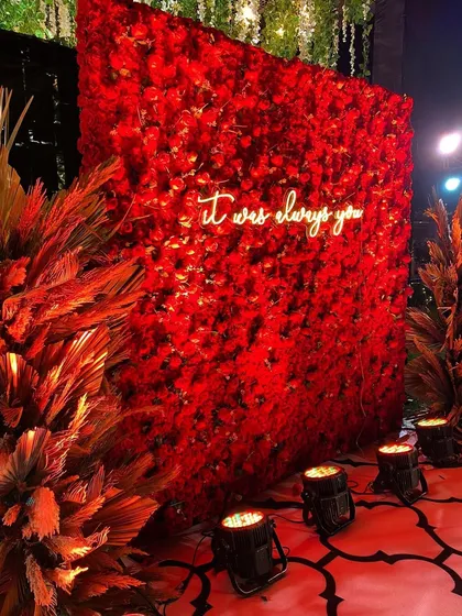 We love adding personal, modern touches to your celebration. This popular selfie booth, featuring a wall of vibrant red roses and a custom neon sign, becomes a memorable spot for you and your guests.