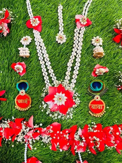 A vibrant red and white floral jewellery set designed for a dohale jevan. This set also features the custom 'Aai' and 'Baba' brooches, along with peacock feathers for a traditional touch.