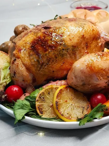 A close-up of our beautiful Easter roasted chicken, garnished with lemon and herbs. A delicious and impressive main course for your holiday meal.