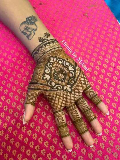 A simple and elegant design for the back of the hand. The central motif is modern and stylish, and it works beautifully with the client's existing tattoo.