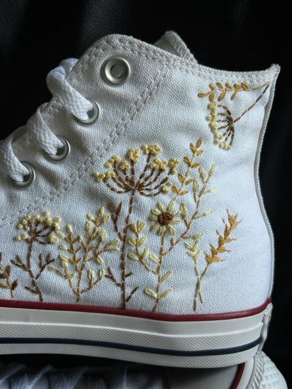 A close-up of the delicate floral embroidery on the canvas.