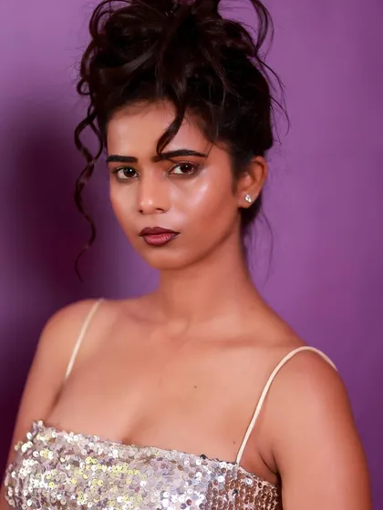 A powerful and direct close-up. Her expression is strong, and the messy updo adds a touch of rebellious glamour.