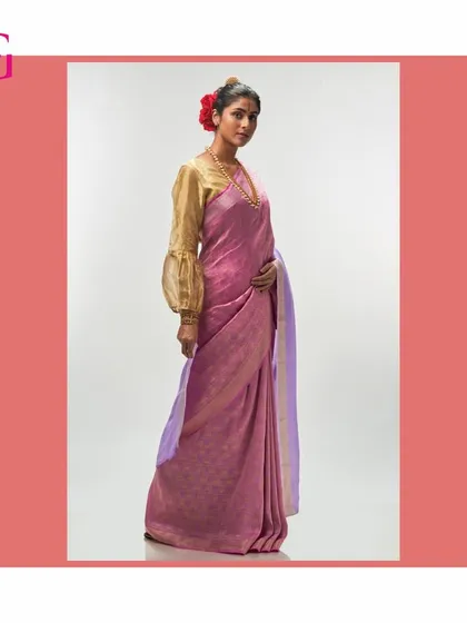 This silk linen saree from the Aadya collection features a lovely pink body and a lavender pallu. It is paired with a modern gold blouse with statement sleeves.