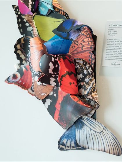 A side view of "A Symphony of Wings," revealing the artwork's description and its three-dimensional presence on the wall.