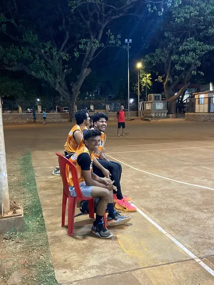 Players taking a break on the sidelines, watching the eliminator match unfold.