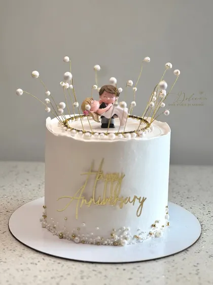A sweet and simple anniversary cake. This design features a cute couple topper surrounded by delicate, pearl-like bubbles, with a "Happy Anniversary" message in gold.