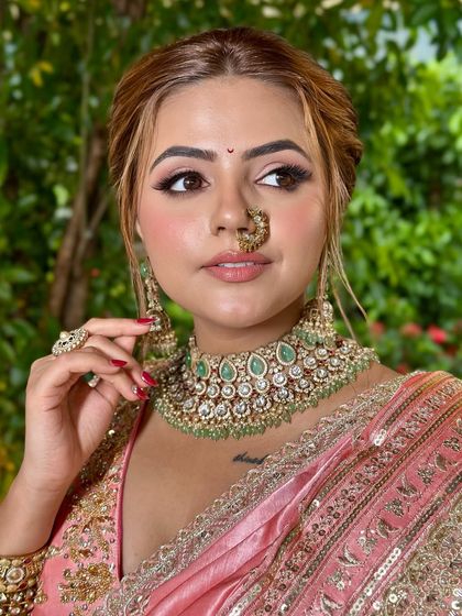 A close-up on the makeup details. The softly smoked-out eye, glowing skin, and traditional nath create a look of pure elegance.
