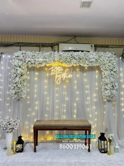 This classic white engagement or anniversary backdrop features a square arch covered in white flowers. The "Better together" neon sign and twinkling fairy lights add a touch of romance and elegance to any indoor space.