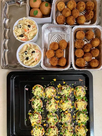 Party starters including mini pizzas, white sauce pasta, and corn & cheese balls.