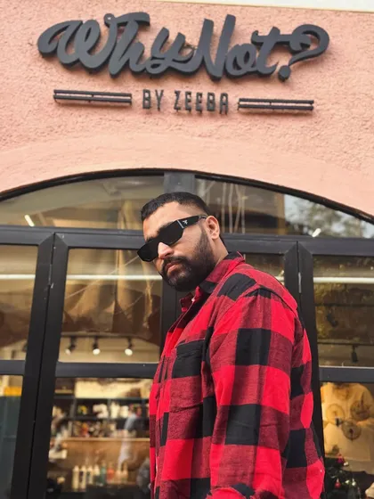 A clean fade haircut paired with a well-maintained beard, pictured right outside my salon.