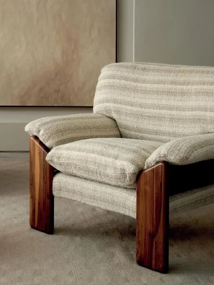 The solid wood frame of this armchair provides a stunning contrast to the soft, woven upholstery. This piece from the Élitis 'Prestige II' collection perfectly balances natural materials with refined textile design.
