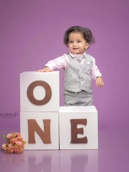 Capturing a new skill, this one-year-old proudly stands up using the 'ONE' blocks for support. It's a wonderful way to document both the age and the developmental milestone.