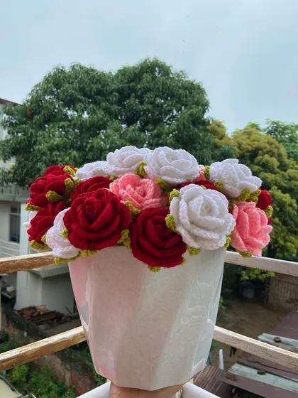 The mixed rose bouquet arranged in a white vase.
