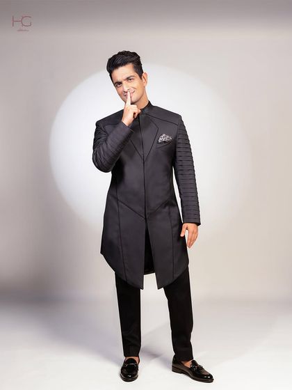 A full-length shot of Ranveer Allahbadia in the custom achkan set. The asymmetrical cut and detailed sleeves make it a truly unique piece for a high-profile event.
