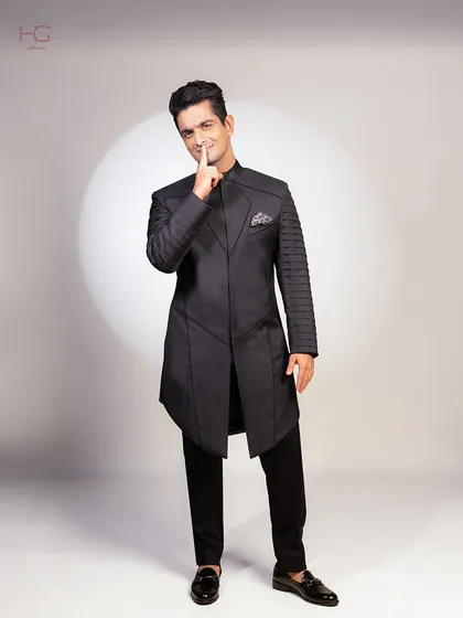 A full-length shot of Ranveer Allahbadia in the custom achkan set. The asymmetrical cut and detailed sleeves make it a truly unique piece for a high-profile event.
