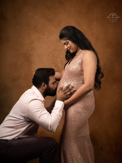 A touching moment as the dad-to-be kisses the baby bump, a classic pose that captures love and anticipation.