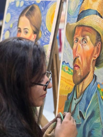 A profile view of the artist at work, capturing her concentration as she adds the finishing touches to her impressionistic oil pastel piece.
