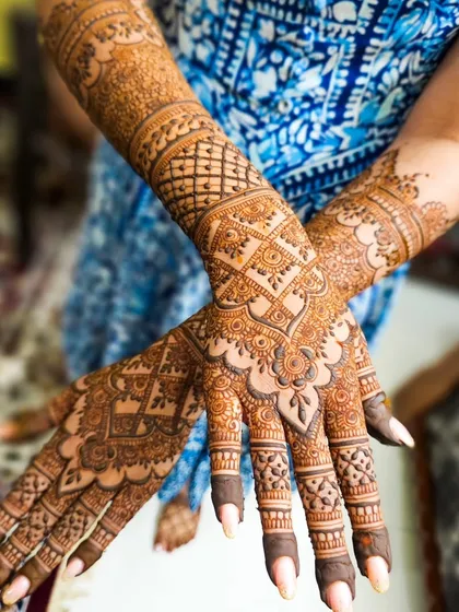 A full bridal set with intricate gridwork on the back of the hands and detailed patterns up the arms.