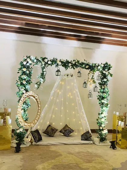 This elegant floor seating arrangement is one of my most versatile designs, ideal for an anniversary or a romantic surprise. I used a canopy of fairy lights, an arch of white roses and greenery, and hanging lanterns to create a dreamy, picture-perfect photo corner.