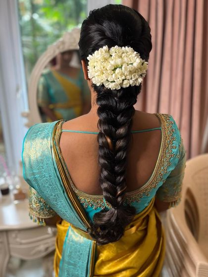 A timeless and simple hairstyle for Sahithya’s muhurtham. This delicate, traditional braid is adorned with a simple string of malli poo for a classic look.