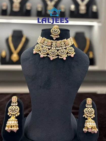 A delicate pink meenakari choker set with matching jhumkas and tikka. This is a great option for a daytime wedding or to match a pastel lehenga.