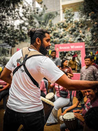 The leader of the drum circle guiding the group, creating a powerful, unified beat at the Garage Sale.