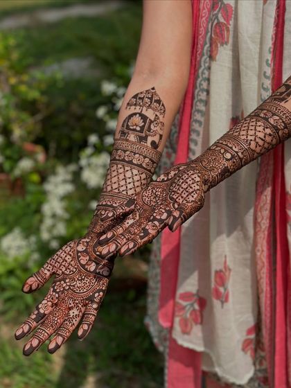 A beautiful outdoor shot of a full-arm design, featuring elephants, jharokhas, and intricate filler patterns.