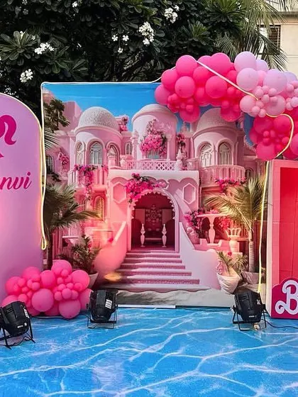 I created a Barbie dream house experience with this poolside setup. The decor includes a stunning backdrop of Barbie's mansion, a giant pink high-heel prop, and a water-effect floor mat.