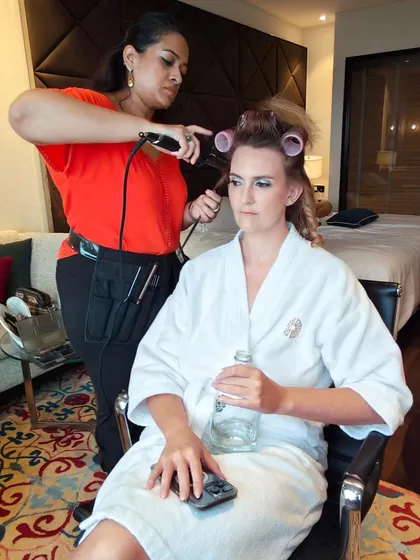 Getting a client ready for a big event. Here I am curling her hair, setting the foundation for a voluminous and glamorous hairstyle.