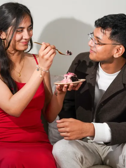 An intimate and playful moment between a couple sharing a bite of cake, telling a story of love and connection.