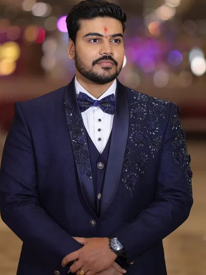 The complete look. A full portrait of a client wearing his hand crafted navy blue tuxedo, showcasing the perfect fit and the elegant silhouette for his special day.
