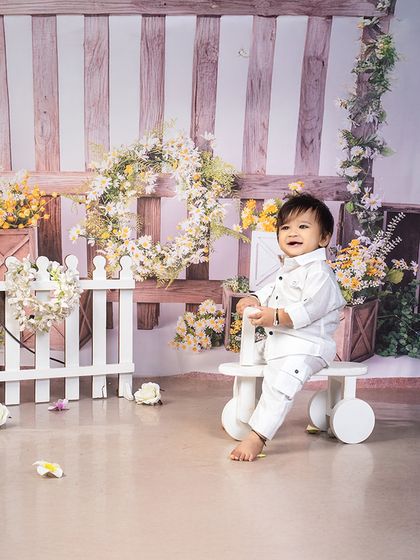 A pure and simple moment of joy. This all-white setup with a rustic floral background creates a beautiful, light-filled portrait.