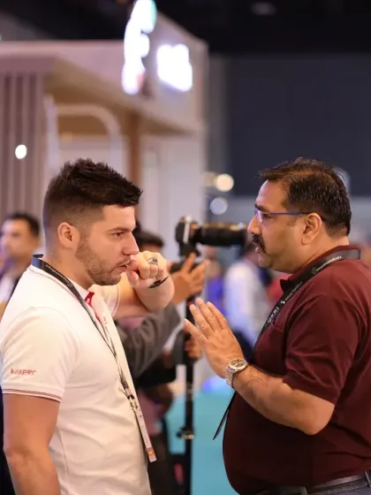 An exhibitor engages in a detailed discussion with a potential client. We facilitate these crucial one-on-one interactions that are essential for building business relationships and securing quality leads.