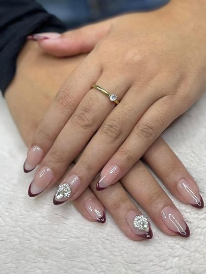 A dark, vampy French manicure accented with large, eye-catching crystal clusters. This is how you create a simple but high-impact, glamorous look.