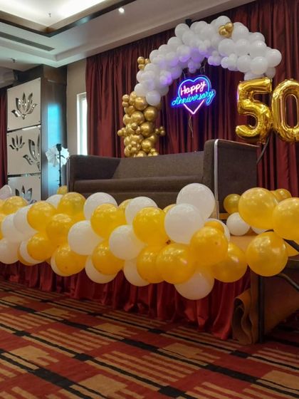 Another angle of the 50th anniversary decor, showing the beautiful contrast between the golden balloons and the white balloon cloud effect.