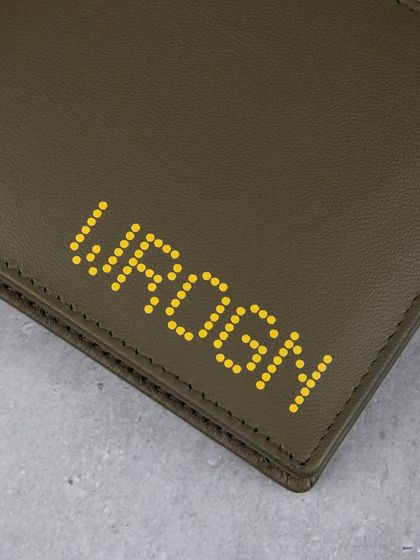 A close-up of the yellow dotted 'WROGN' logo on the olive wallet.