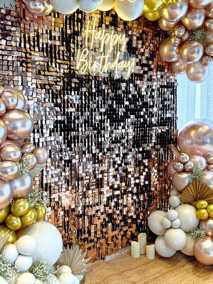 The "Happy Birthday" neon sign glowing against the rose gold shimmer wall. It's these details that create a focal point and set the mood for the celebration.