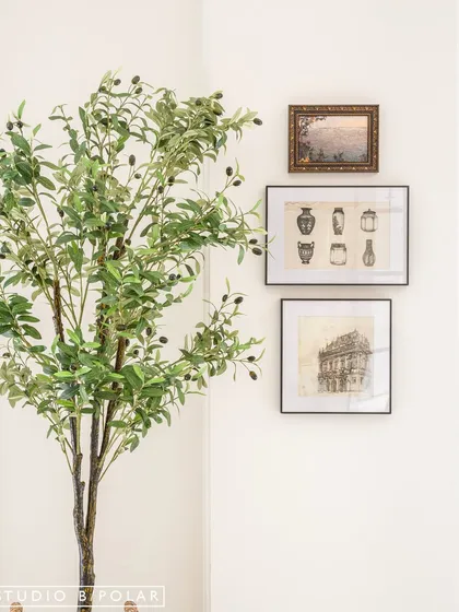 We believe in bringing nature indoors. A faux olive tree and botanical prints in the corner of the dining room add a touch of green and a sense of life to the space.