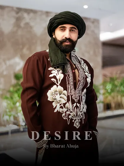 Power in subtlety. This deep maroon kurta is elevated by bold, contrasting ivory embroidery that frames the neckline and cuffs. It is a design that speaks of heritage and sophistication, tailored for a commanding presence.