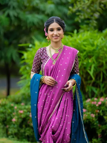 This full-length shot showcases how the complete look comes together. The minimal makeup complements the rich magenta nauvari and the intricate blouse, creating a balanced and regal appearance.