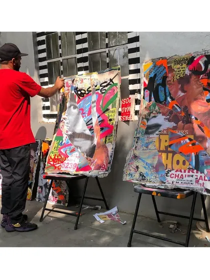 Here I am in the studio, working on a couple of pieces from the 'Stick No Bills' décollage series. This shot shows the scale of the canvases and the hands-on process of layering and painting.