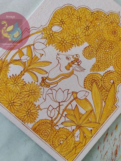 The Pichwai Cow painting after the first layer of yellow. This bright, sunny color fills the flowers and details, creating a beautiful contrast with the white of the cow.