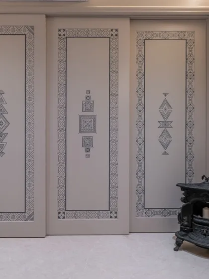 A door can be a canvas. For this project, I drew inspiration from Aztec art and Moroccan tribal patterns to create a contemporary design with deep cultural roots. Hand-painted on-site, these doors, paired with a cast iron fireplace, show how artistry can be woven into every detail of a home.