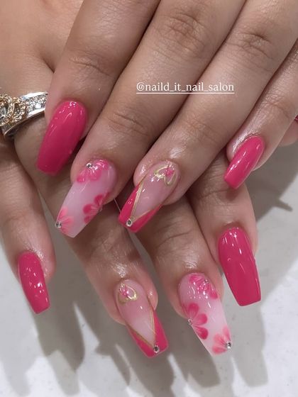 A vibrant pink set on coffin nails, combining solid color with accent nails that feature a sheer base, delicate 3D pink flowers, and subtle gold line details.