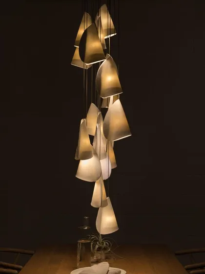 Another intimate dining setting, where a small cluster of Bocci 21 pendants provides focused light over the table. The unique shape of each shade adds character and warmth.