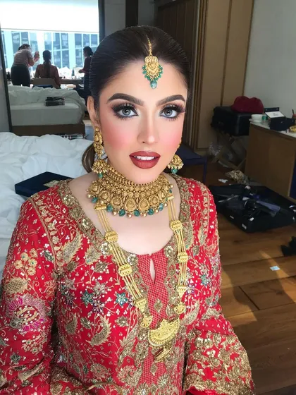 A beautiful Pakistani-inspired bridal look. We created a bold look with dramatic eyes and classic red lips to match her ornate, traditional outfit.