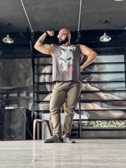Practicing posing in a classic bicep flex. It's an art form that requires as much practice as lifting itself.