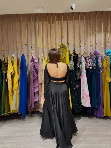 The back of this black outfit is the real showstopper. A deep backless design adds a touch of drama and glamour.
